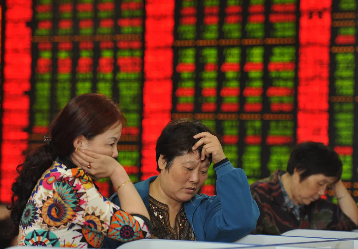 Investors check share prices in a stock firm in Fuyang, Anhui Province, east China. (AFP)